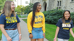 Three alumni walking in front of UHall