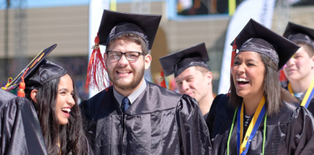 A smiling group of new graduates at commencement