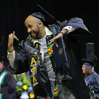 Graduate dancing on the commencement stage
